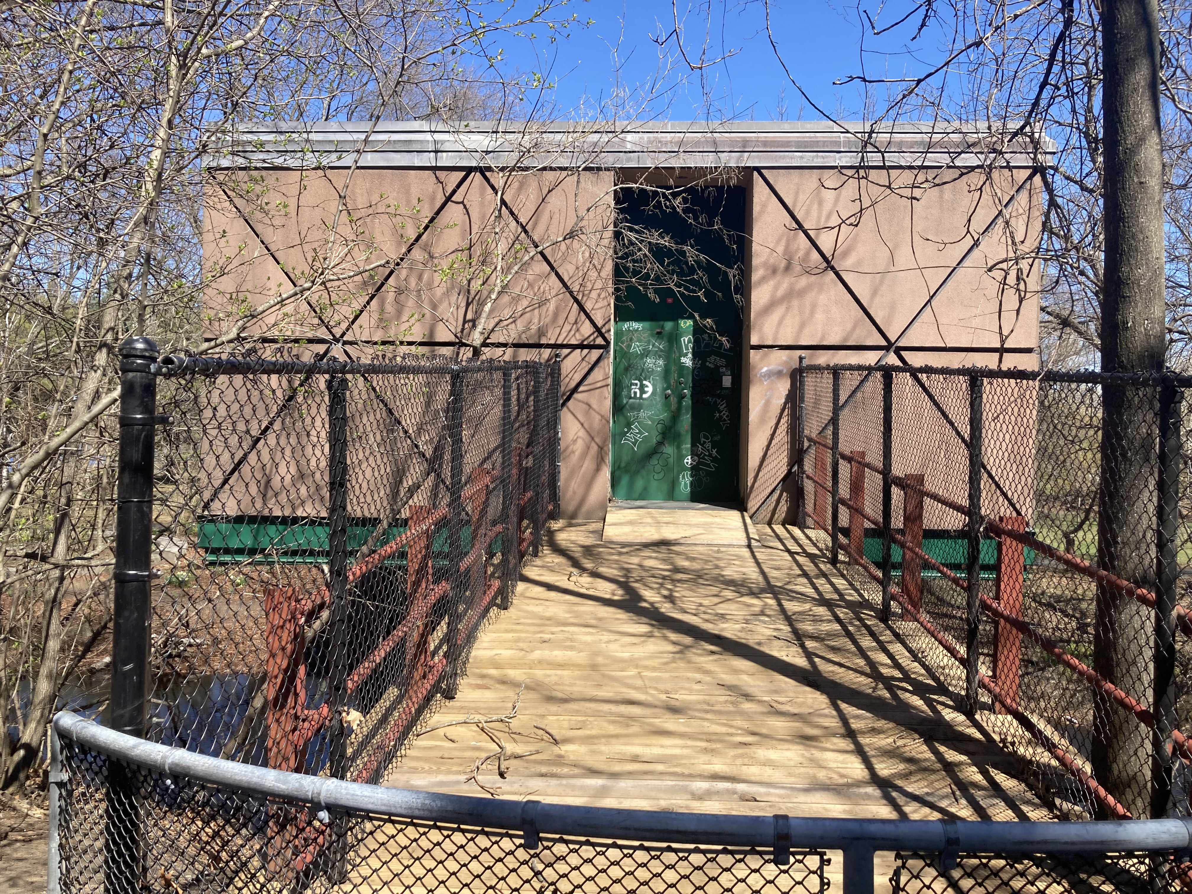 The entrance to the strange building is across a bridge.